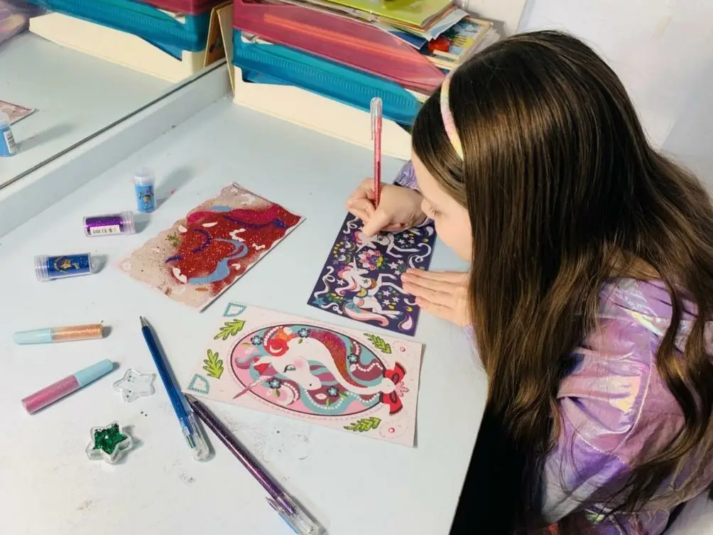 Carolina decora dei disegni di unicorni con il set di glitter biodegradabile portato da Parigi.