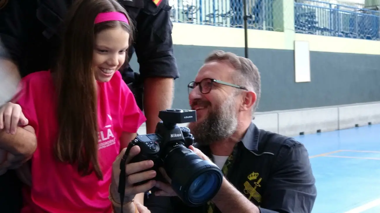 Carolina, con la maglietta di ELA, guarda con il fotografo le immagini del calendario sullo schermo della macchina fotografica.
