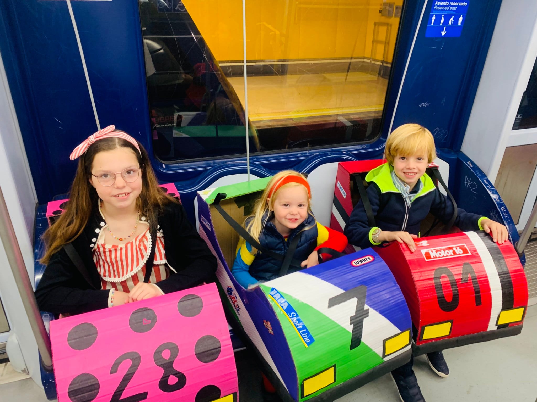 Carolina e i suoi fratelli viaggiano in metropolitana con i loro costumi da autoscontro diretti al concorso.