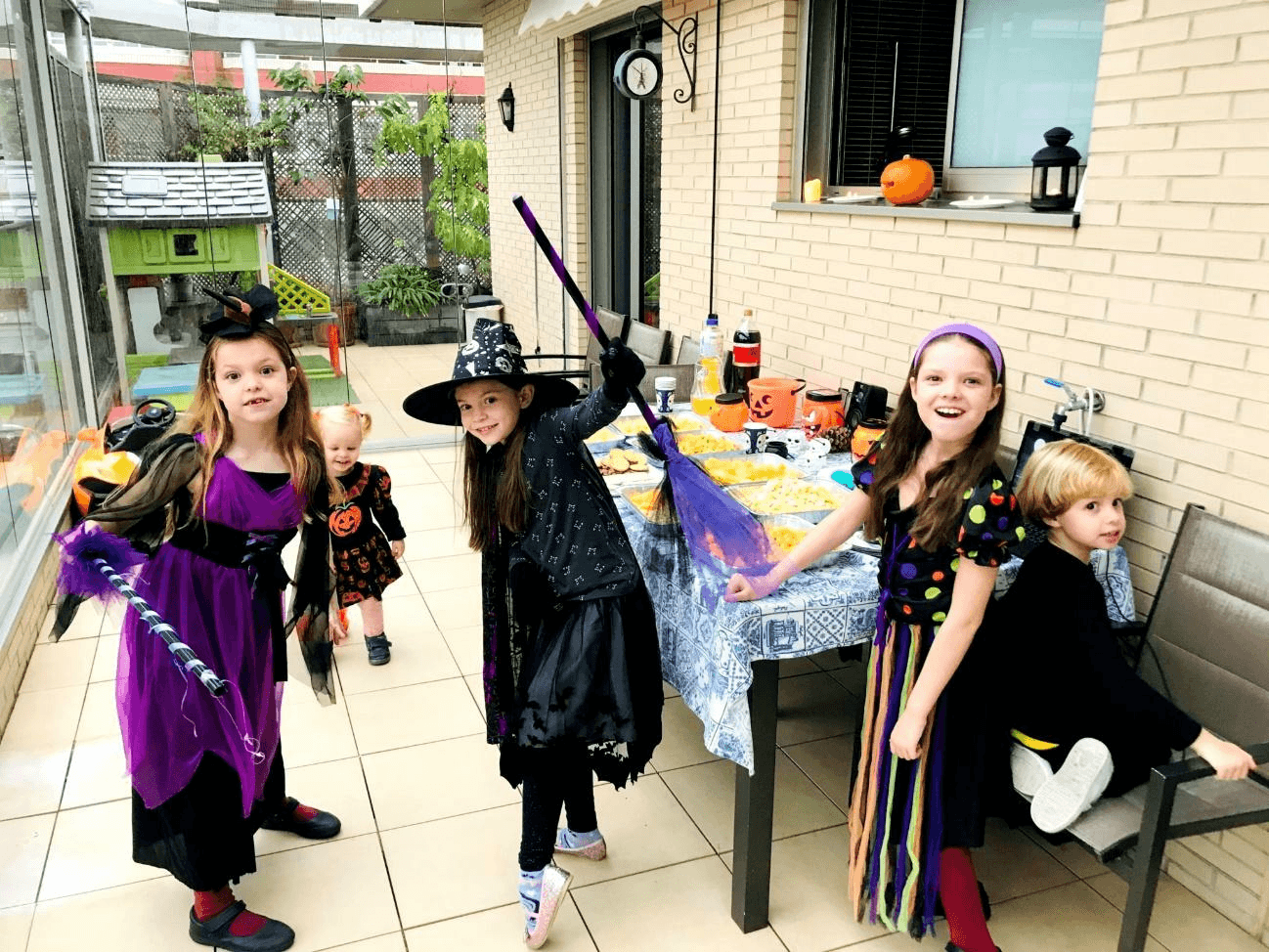 Festa di compleanno di Carolina Purpurina: i bambini travestiti da streghe accanto al tavolo decorato con delle zucche.