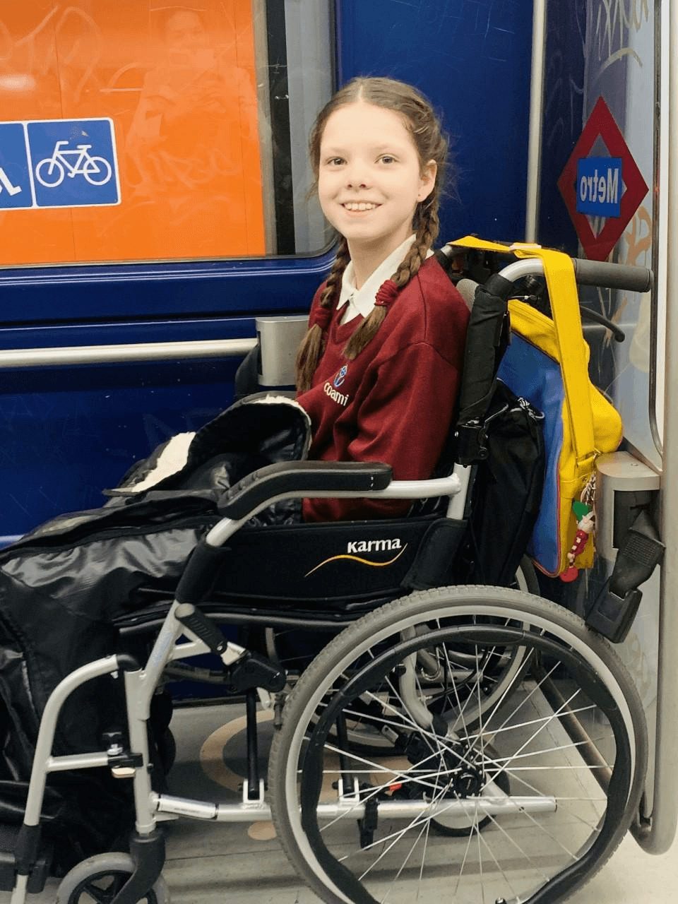 Carolina, sulla sua sedia a rotelle e con l'uniforme scolastica, viaggia ogni giorno nella metropolitana di Madrid.