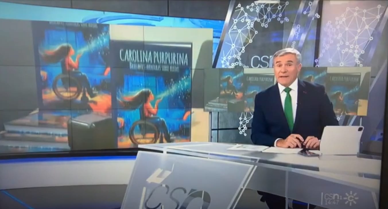 Un conduttore del telegiornale in studio, con la copertina di «Carolina Purpurina» sugli schermi della scenografia.