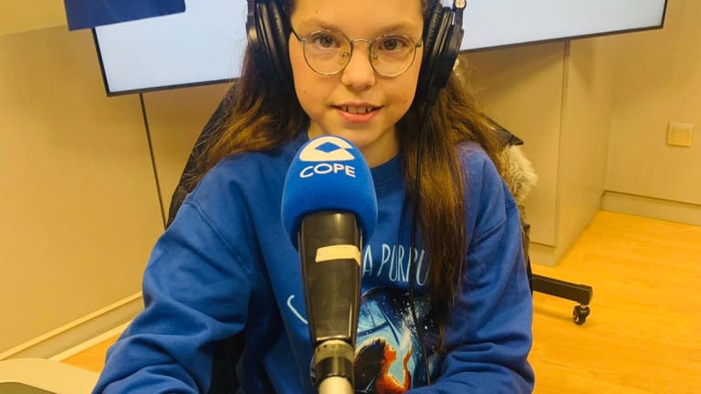 Isabel, con le cuffie e la felpa di «Carolina Purpurina», parla davanti al microfono di COPE nello studio.