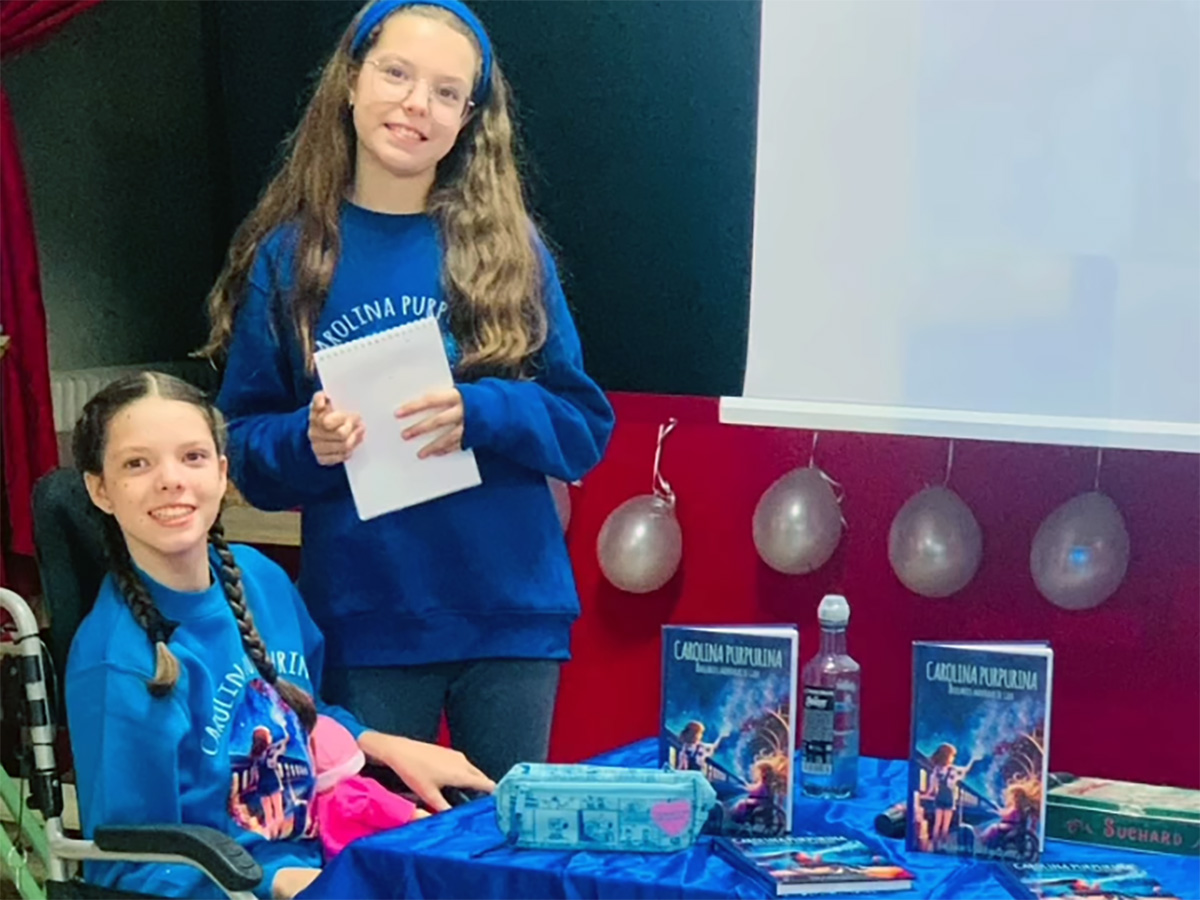 Isabel e Carolina accanto al tavolo dei libri durante l'incontro al CEIP Marqués de Valero, a Béjar.