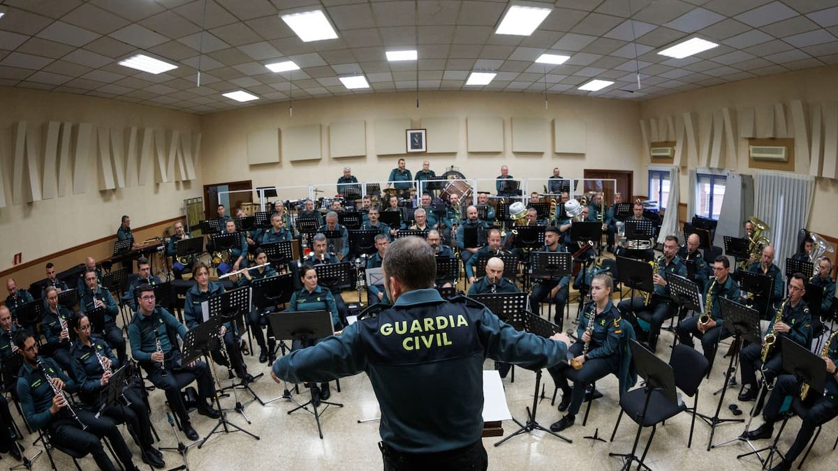 Un direttore con la giacca della Guardia Civil, di spalle, dirige la prova della banda che ha tenuto un concerto a favore dell’associazione.